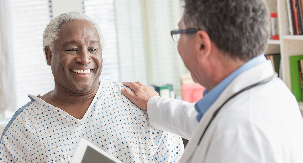 Medicare eligible male patient with a male doctor discussing Medicare coverage