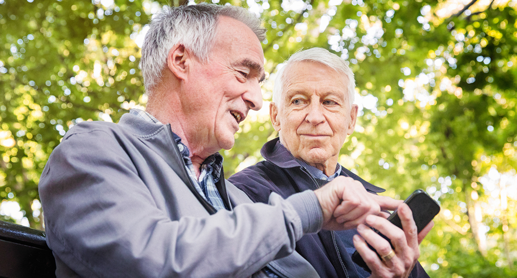 An older gentleman explaining Medicare Part C costs to another Medicare eligible man